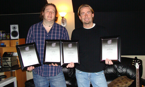  Joey Moi (left) and Chad Kroegerwith just a few of their newly-received SOCAN No. 1 Song Awards. (Photo: Lynn Ross)