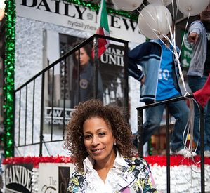 Actress Tamara Tunie shows off her winning smile volgende to The Daily News parade float.