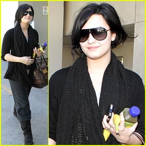  Demi Lovato gets accompanied 由 some police officers as she heads out of LAX airport in Los Angeles o