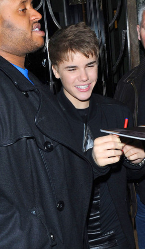Justin Bieber takes a snap on his IPhone as he stops at La Portes Des Indes restaurant in London