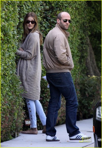 Rosie Huntington-Whiteley and her boyfriend Jason Statham peek into the bushes of a friends home
