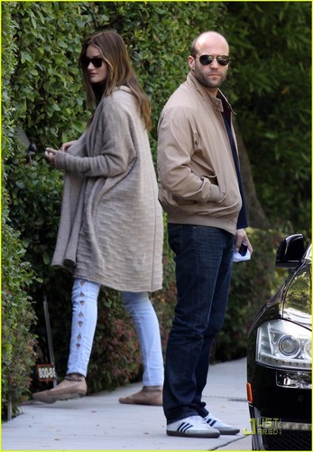 Rosie Huntington-Whiteley and her boyfriend Jason Statham peek into the bushes of a friends home