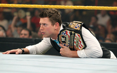 What title is The Miz holding while watching a  match?