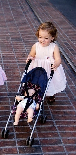  REenesme pushinf her doll in her pram