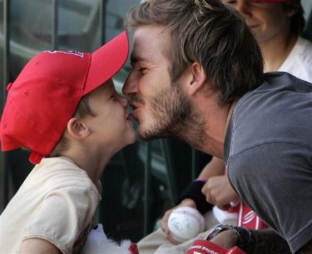 Soccer star David Beckham gets a kiss from son Cruz during a baseball game between the Los Angeles 