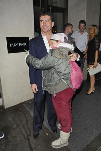  Simon Cowell kisses a tagahanga on the cheek