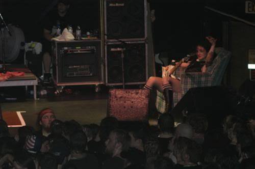 Lyn-Z Way sitting on a couch on stage