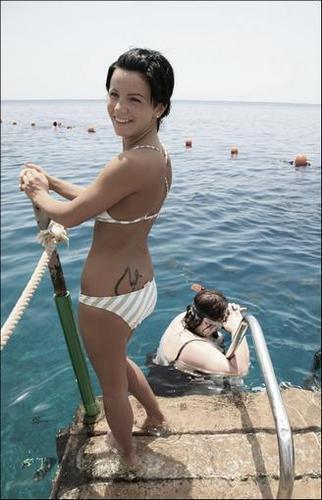 Замечательная Юлия Ахмедова привлекательно позирует на солнечном пляже в купальнике на фото