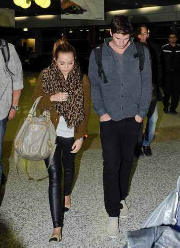  Miley Cyrus is all smiles as she arrives in Brisbane, Australia with boyfriend Liam Hemsworth.